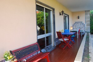 Un espace extérieur aménagé avec un banc, une table et des chaises.