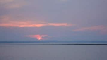 A calm body of water with a sunset in the distance.