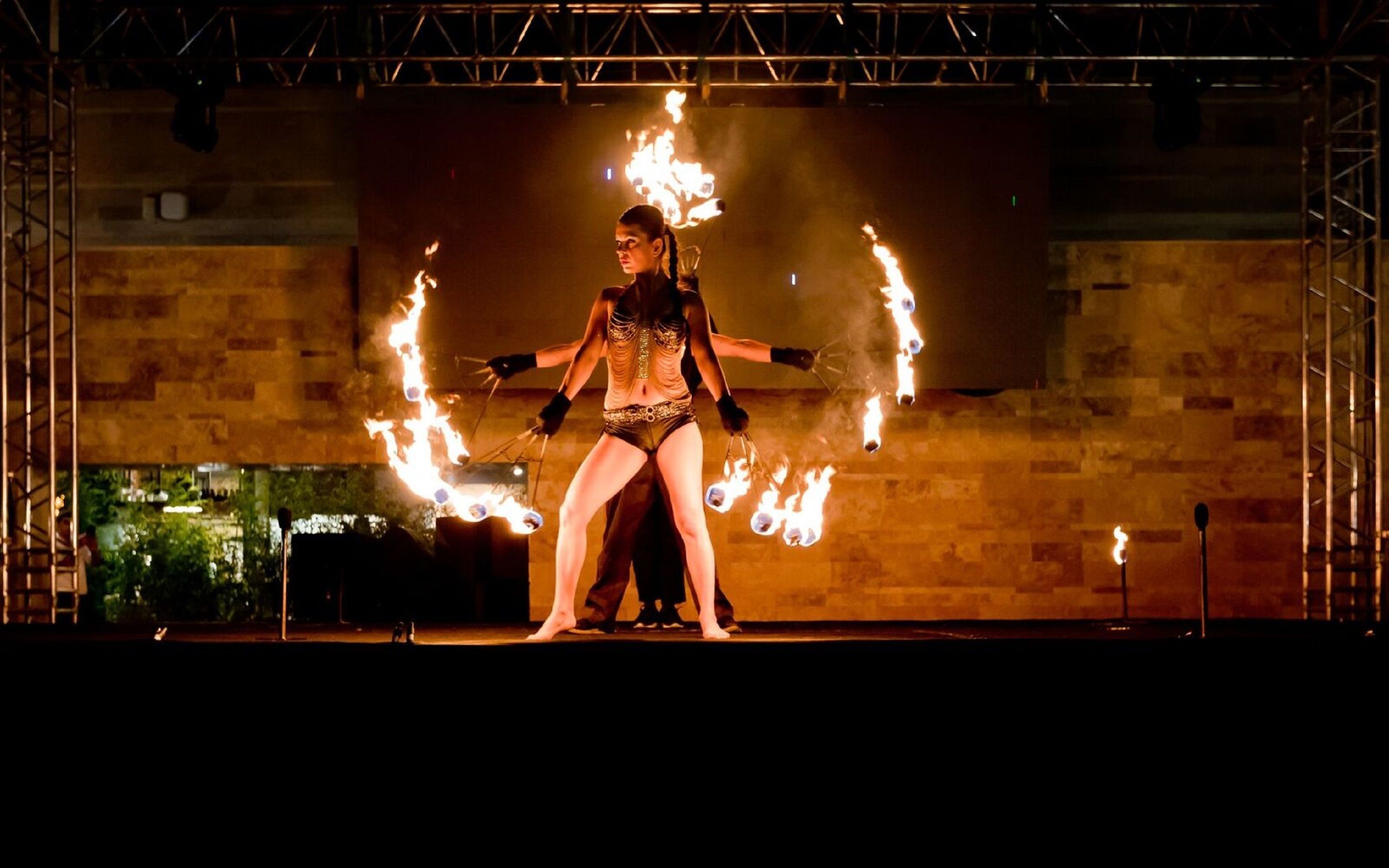 Un artista con aros de fuego en el escenario.
