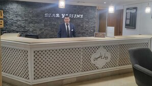 A reception desk with a stone wall backdrop and a sign reading "DIAR YASSINE". - Diar Yassine (Djerba Midun)