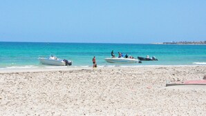 A beach with boats and people. - Diar Yassine (Djerba Midun)