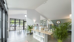A modern kitchen with a central island, white cabinetry, and a large window providing a view of the outdoors. - Garden & City Mont Ventoux - Malaucène (Malaucene)