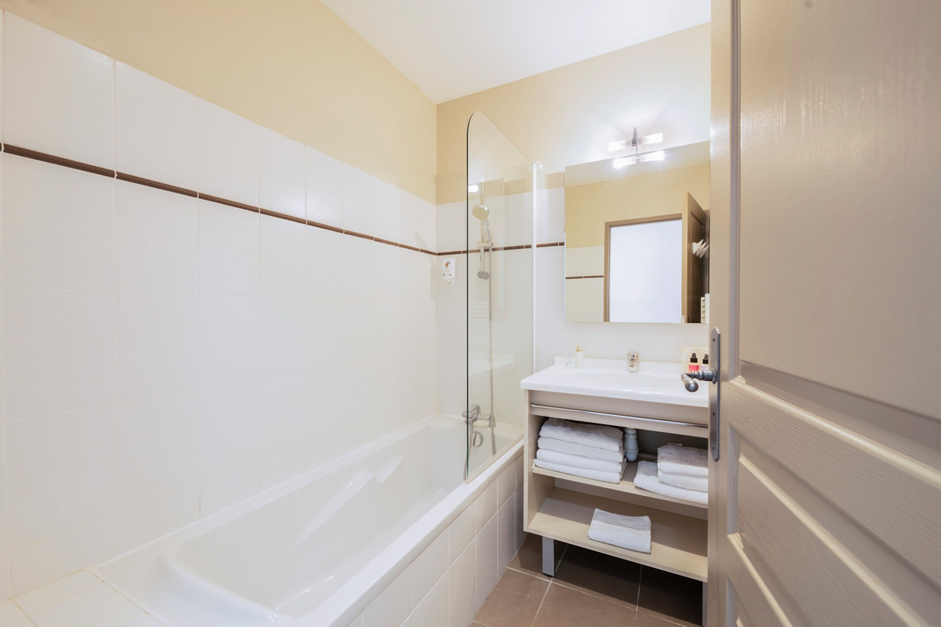 Une salle de bain moderne avec une baignoire, une douche à parois de verre et un meuble-lavabo avec un miroir.