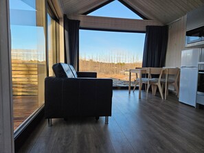 Un intérieur moderne comprenant un canapé, une table à manger, des chaises et un coin cuisine.