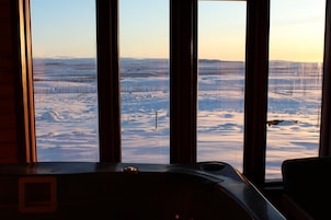 Una habitación con un ventanal que ofrece vistas a un paisaje nevado.