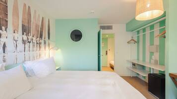 Un dormitorio con cama, ventanal redondo, armario y lámpara colgante.