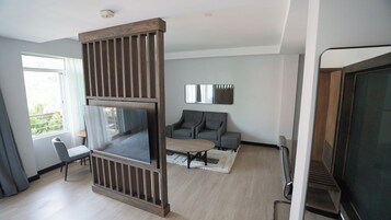 Un salon moderne doté d’un grand téléviseur à écran plat, d’un canapé, d’une table basse et d’une cheminée.