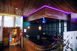 Een bar met houten latten, een toonbank en een brandblusser.