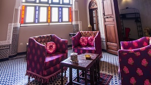 Una habitación con baldosas de piso estampadas, un ventanal con vidrieras y muebles tradicionales.