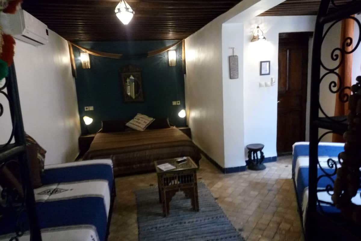 A bedroom with a bed, bedside tables, a nightstand, a dresser, and a window.