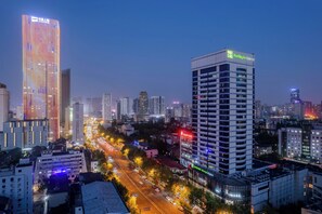 A cityscape at dusk with modern buildings, including a Holiday Inn Express.