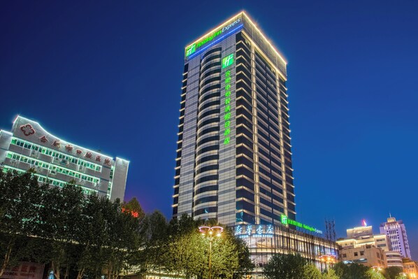 A tall hotel building with a prominent sign for Holiday Inn Express at the top.