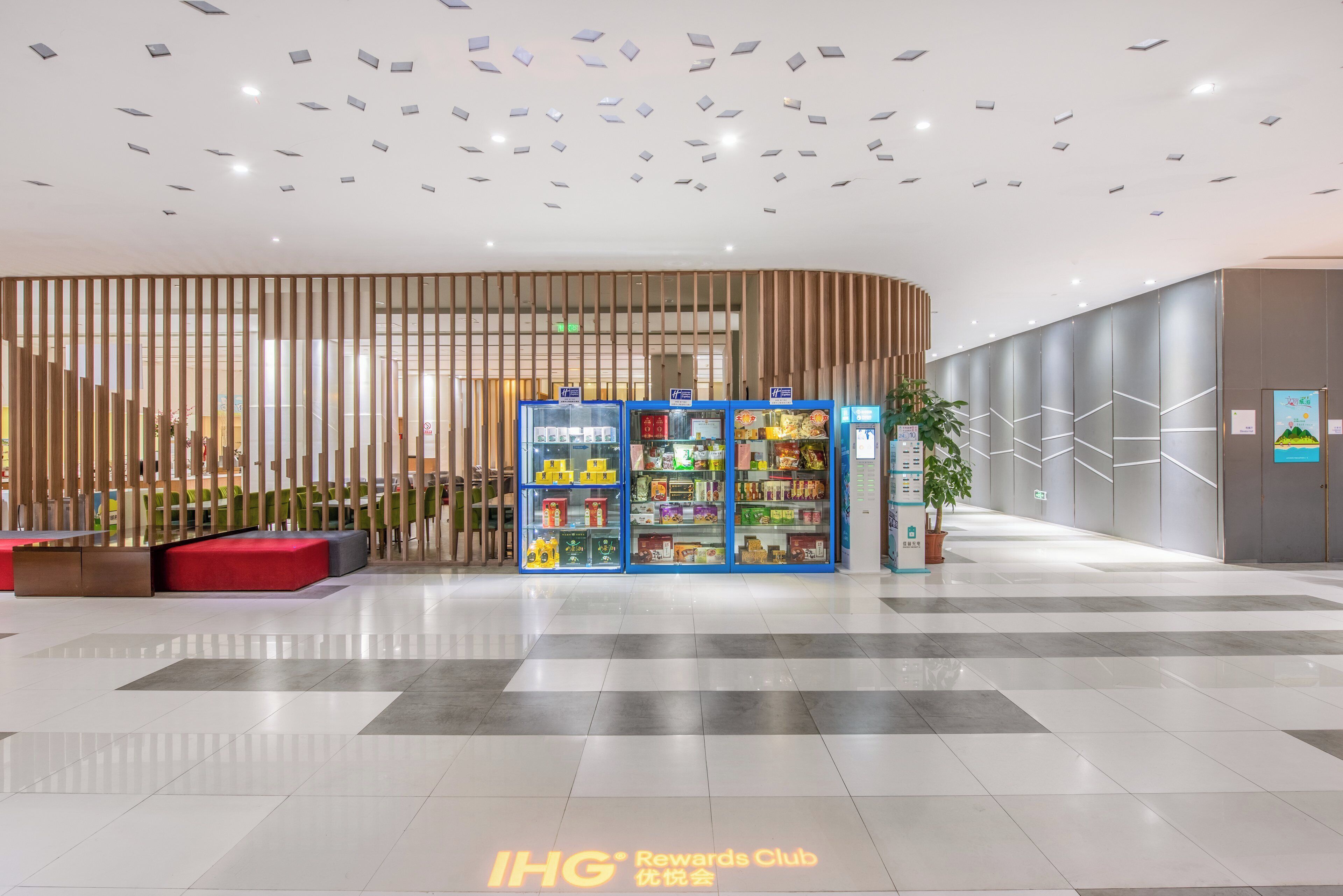 Un interior modern amb una zona de seients, una exposició de productes i un cartell del IHG Rewards Club.