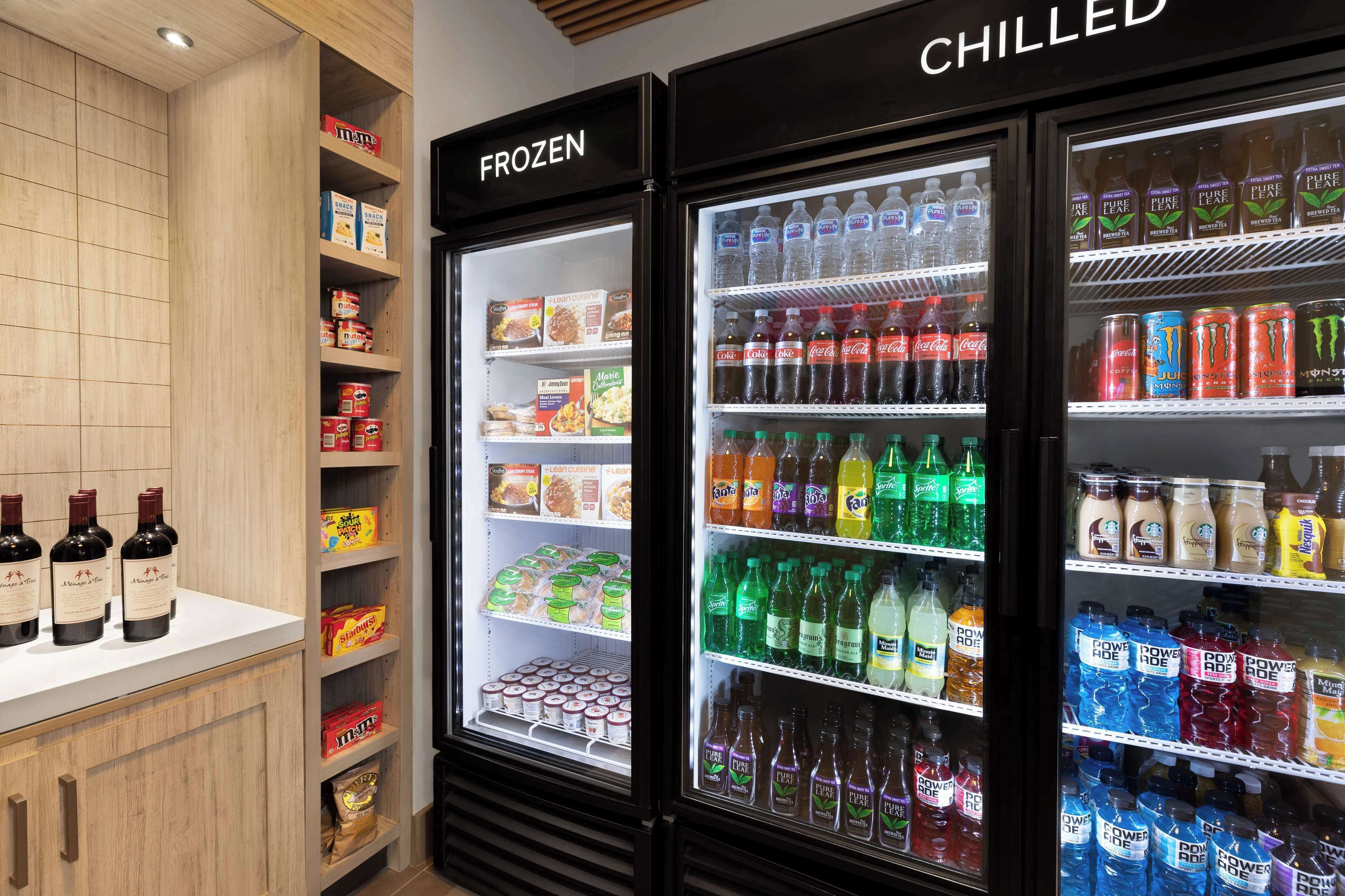 Mostrador refrigerado con diferentes bebidas y aperitivos.
