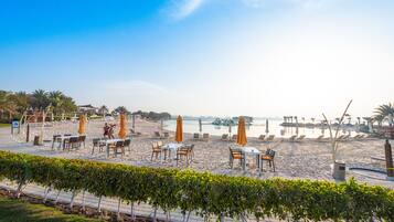 On the beach, white sand, sun loungers, beach umbrellas