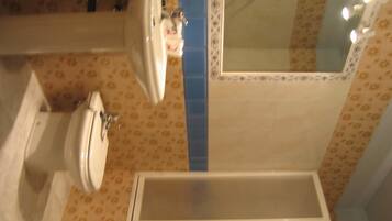 Un baño con inodoro, lavamanos y bañera.