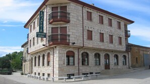 A multi-story building with a stone facade, balconies, and a sign indicating it is a rural tourism property. - Centro de Turismo Rural Lajafriz (Fonfria)