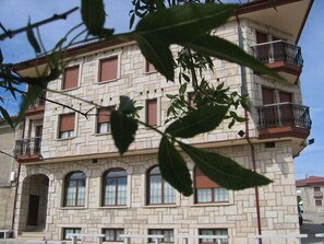 A multi-story building with a stone facade, multiple balconies, and arched windows. - Centro de Turismo Rural Lajafriz (Fonfria)
