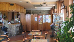 A restaurant with wooden paneling, a bar area, and multiple tables and chairs. - Centro de Turismo Rural Lajafriz (Fonfria)