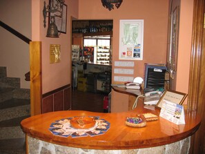 A reception area with a wooden counter, a telephone, a calendar, and a menu board. - Centro de Turismo Rural Lajafriz (Fonfria)