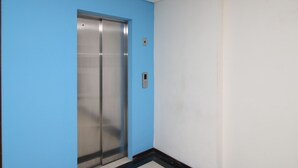 A hallway with a blue wall and a white door.