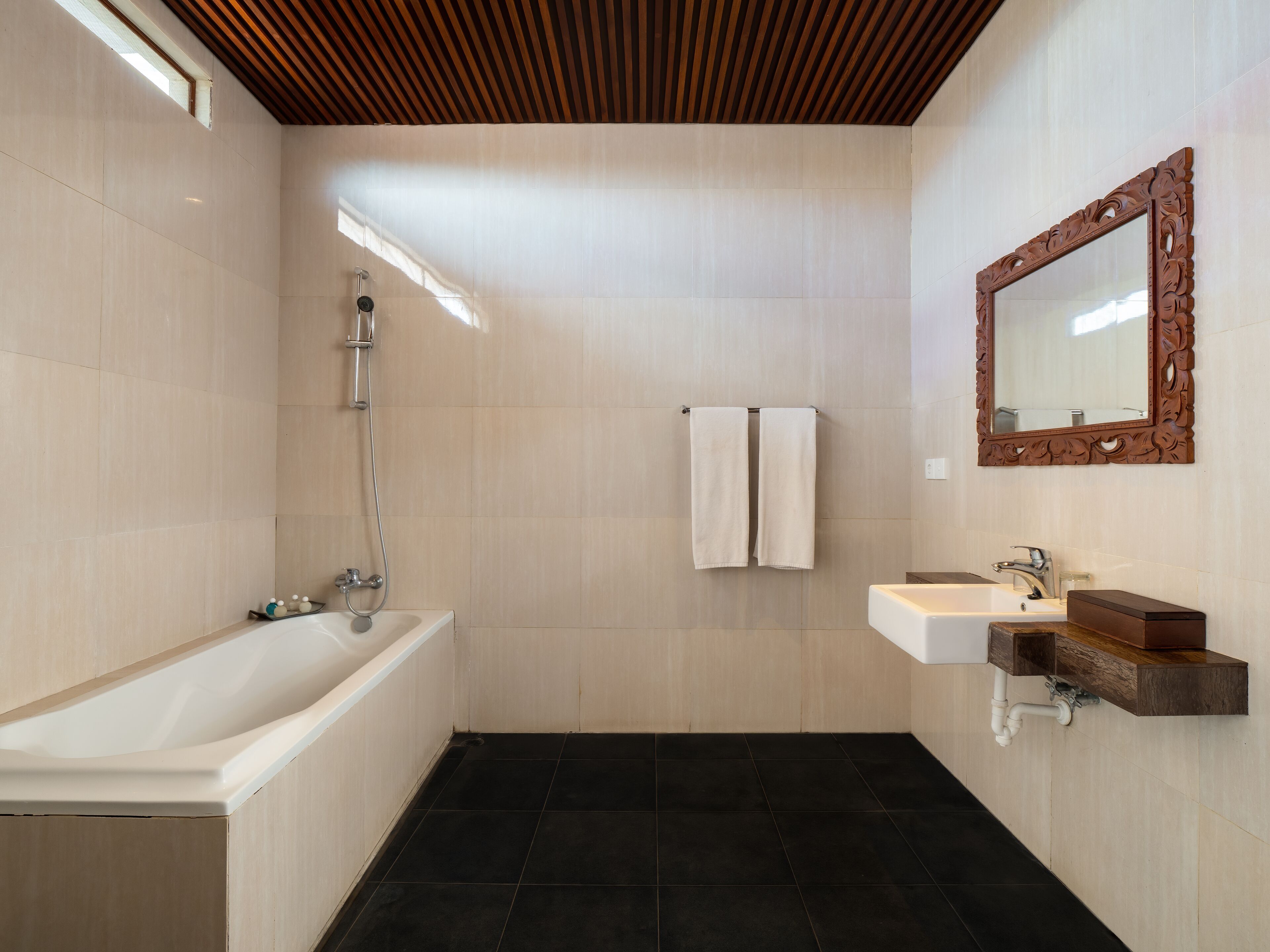 A modern bathroom with a bathtub, a sink, and a mirror.