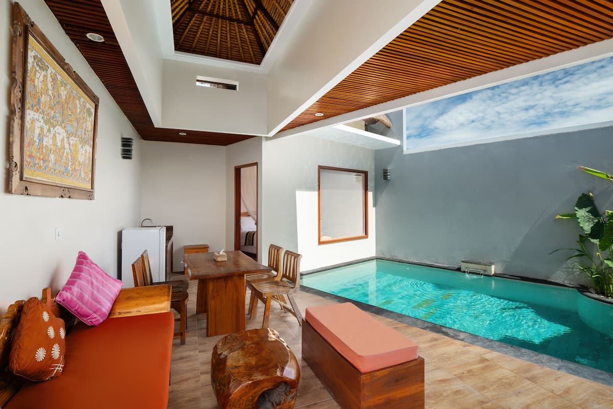 Una habitación moderna con techo de madera, piscina y zona de comedor.