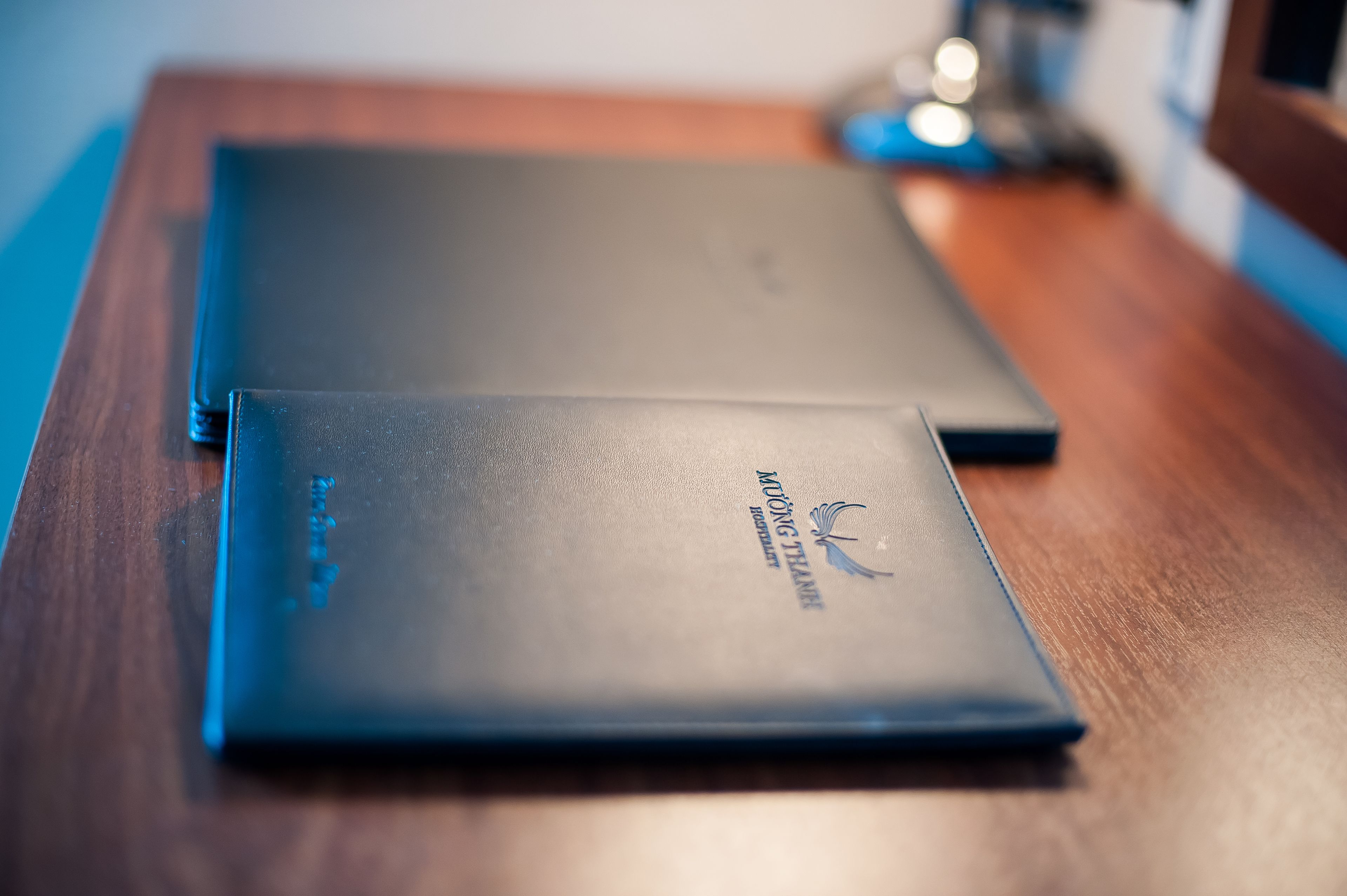 Two closed laptops on a wooden table.