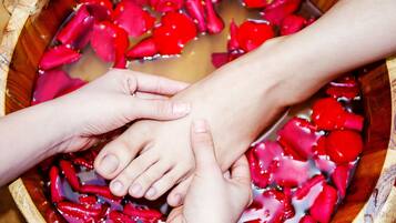 A wooden bowl filled with water and red rose petals.
