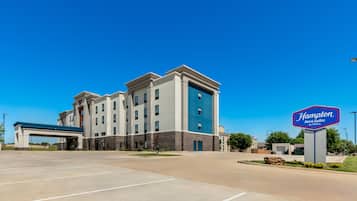 Edificio de Hampton Inn & Suites by Hilton con un estacionamiento al frente.