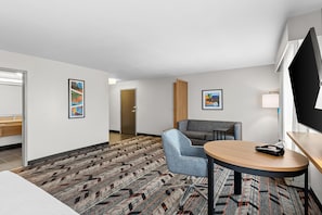 A hotel room with a bed, a desk, a chair, a small table, and a carpeted floor. - Hampton Inn & Suites Pauls Valley (Pauls Valley)