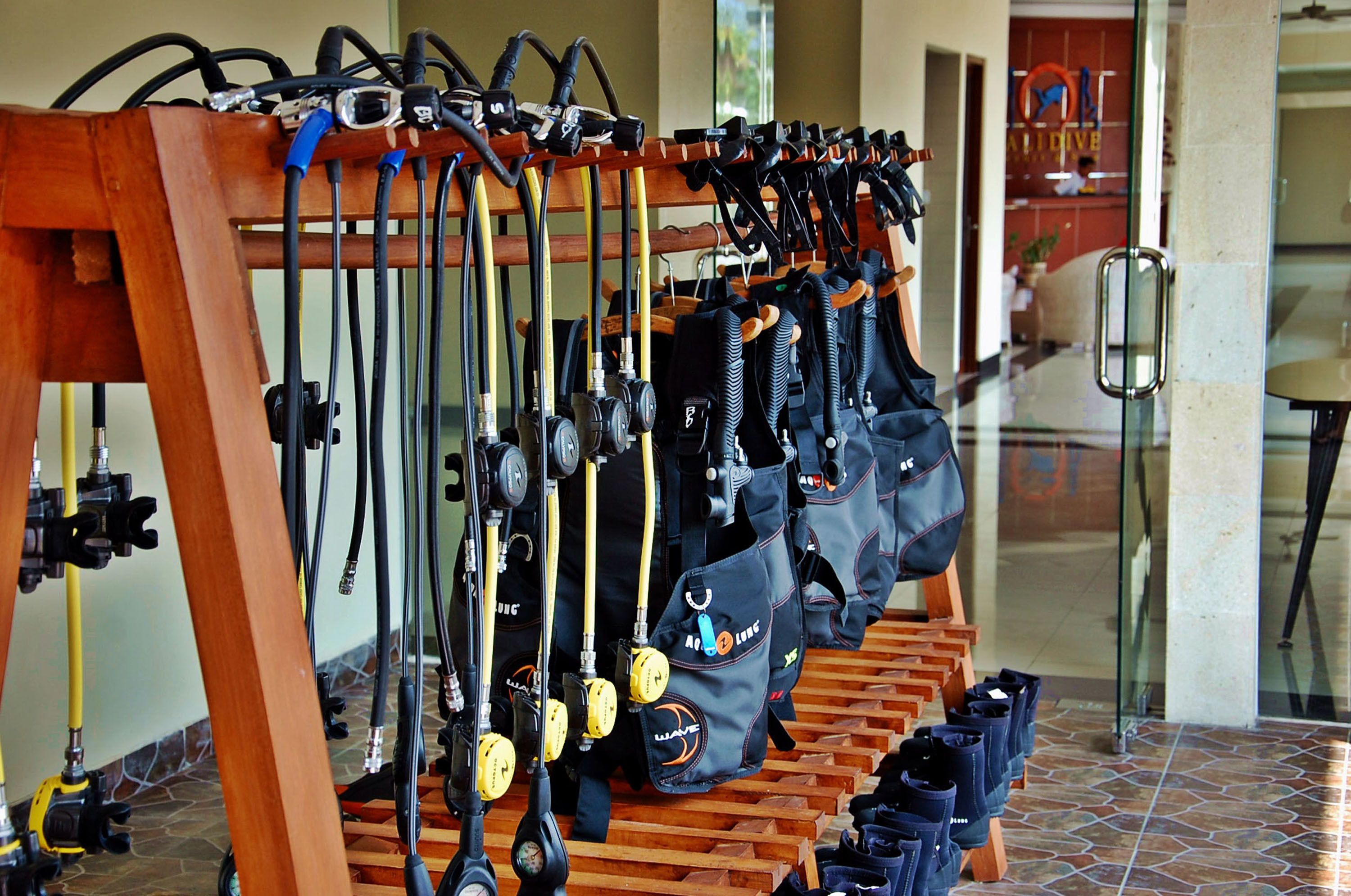 A rack of diving gear and bags in a lobby area.