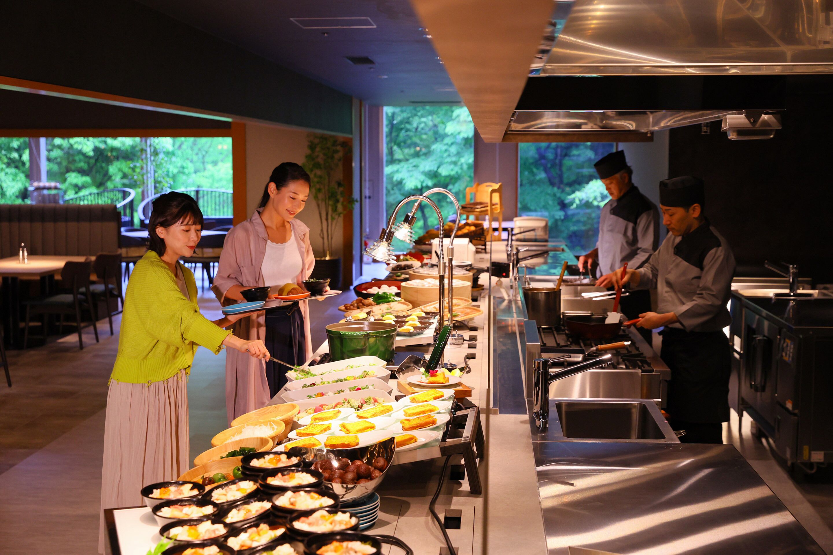 A buffet setup with various food items and staff serving.
