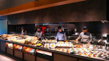 A buffet setup with multiple food stations and chefs preparing food.