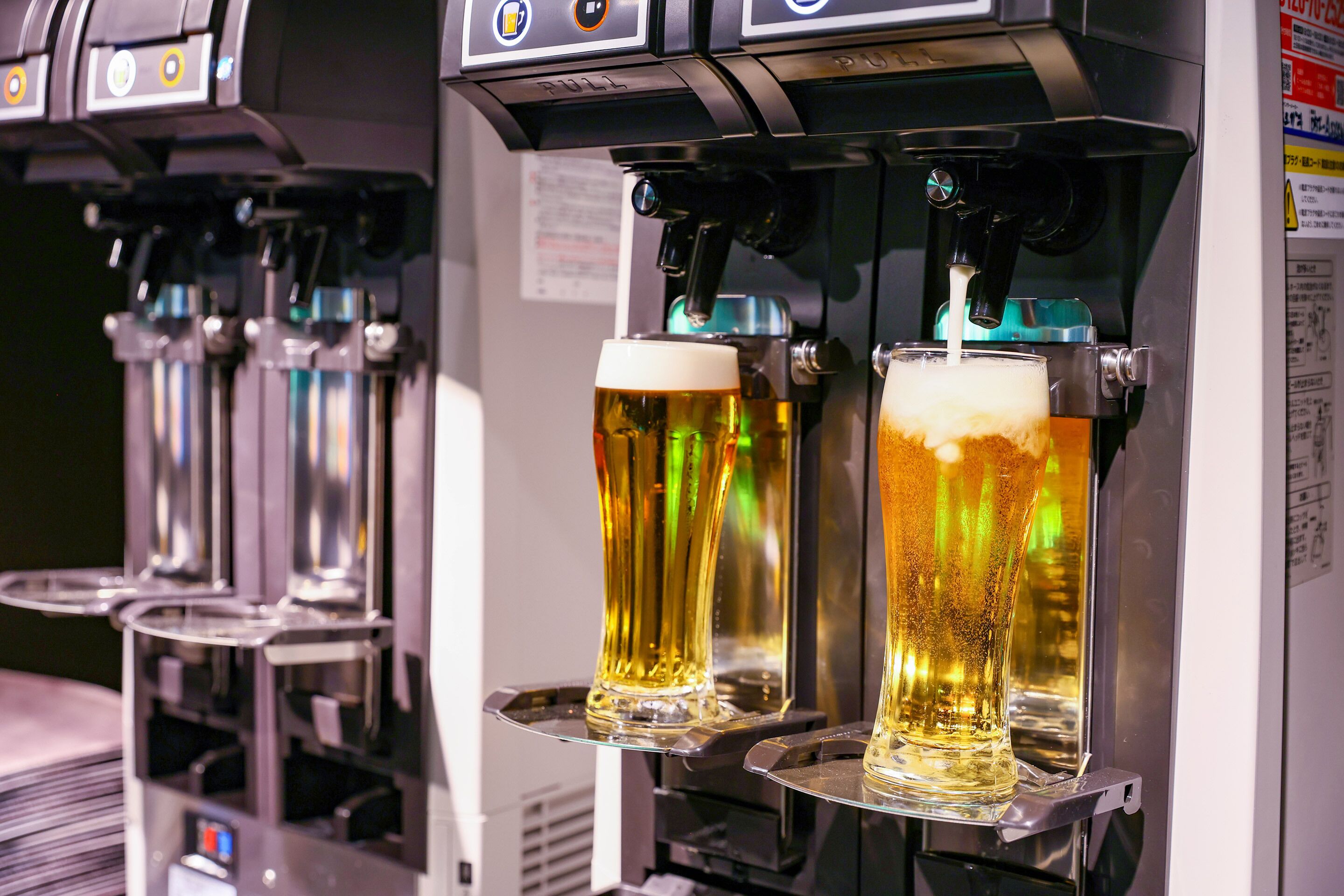A barista preparing beer in a commercial coffee machine.