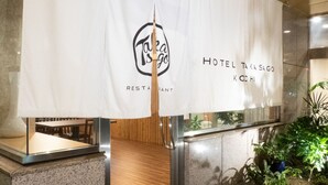 A hotel entrance with a white banner displaying the logo and name 'Hotel Takasago Koshiji'. - Hotel Takasago (Kochi)