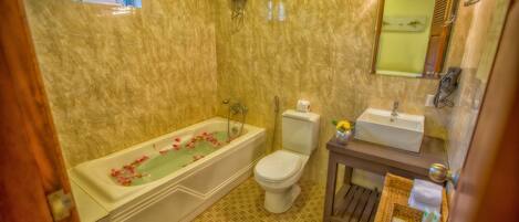 A bathroom with a bathtub, toilet, sink, and a small window.