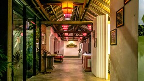 A hallway with a wooden ceiling, a staircase, and a reception desk. - River and Villa (Siem Reap)