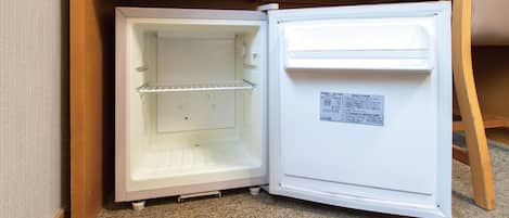 Un refrigerador blanco con un compartimento congelador en la parte superior y el compartimento principal debajo.