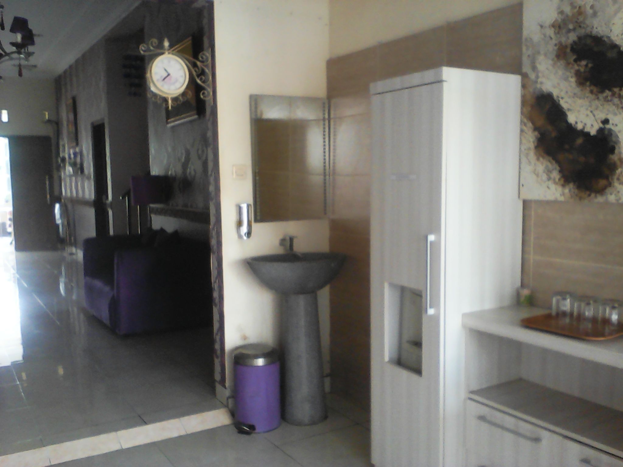 Una cocina moderna con un lavabo, un cubo de basura y un refrigerador.