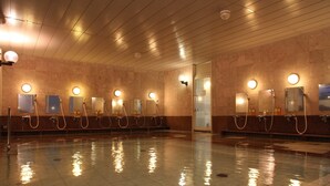 Una piscina pública con varios vestuarios, cada uno con un espejo y un lavabo.