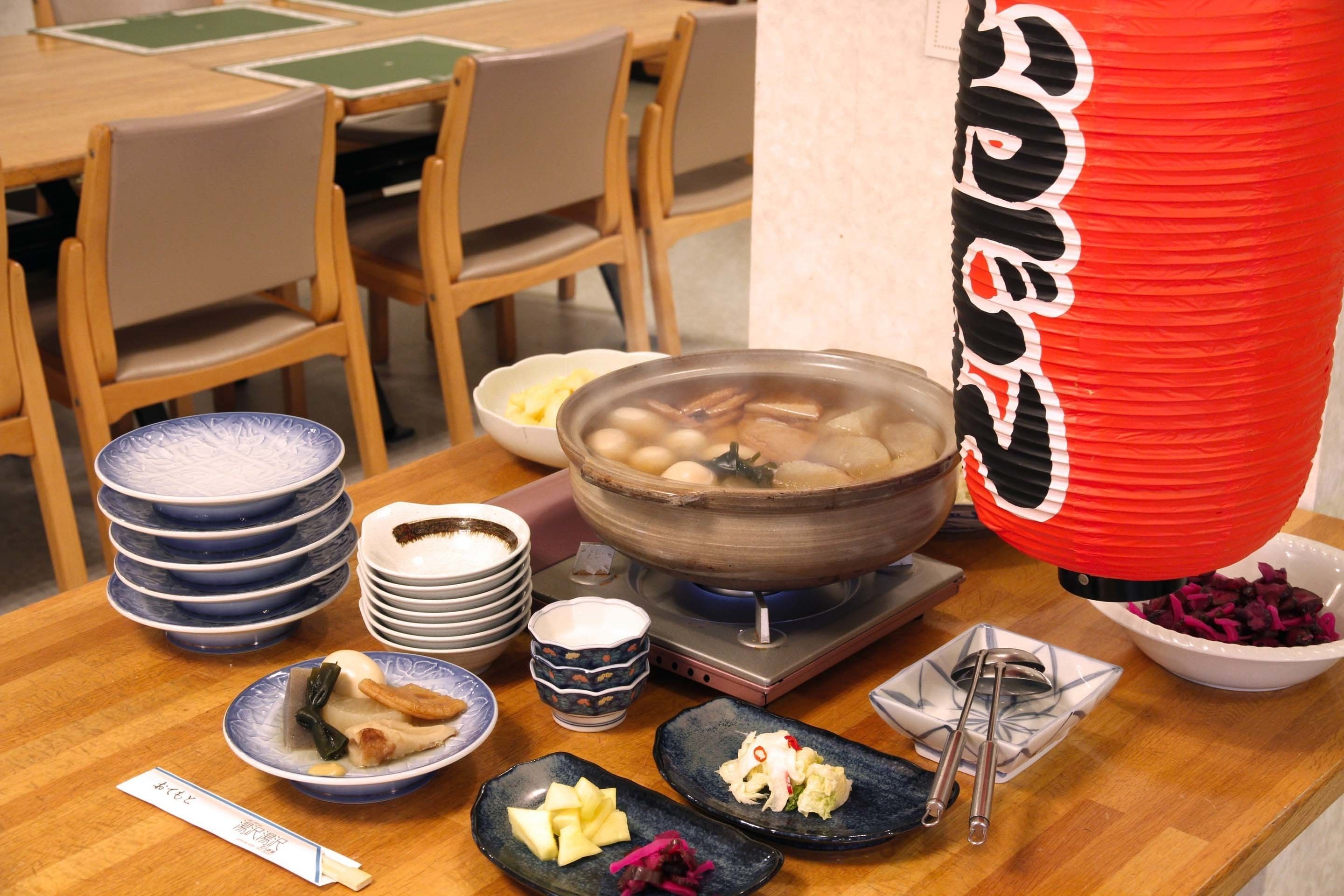 A dining table with various dishes, including a bowl of soup, plates, and bowls of food.