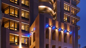 A multi-story hotel with a modern design, featuring balconies, large windows, and a prominent entrance with signage. - La Vida Hotel (Taichung)