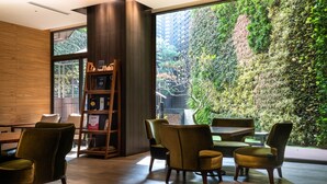 A modern interior with a large window, a bookshelf, and seating areas. - La Vida Hotel (Taichung)
