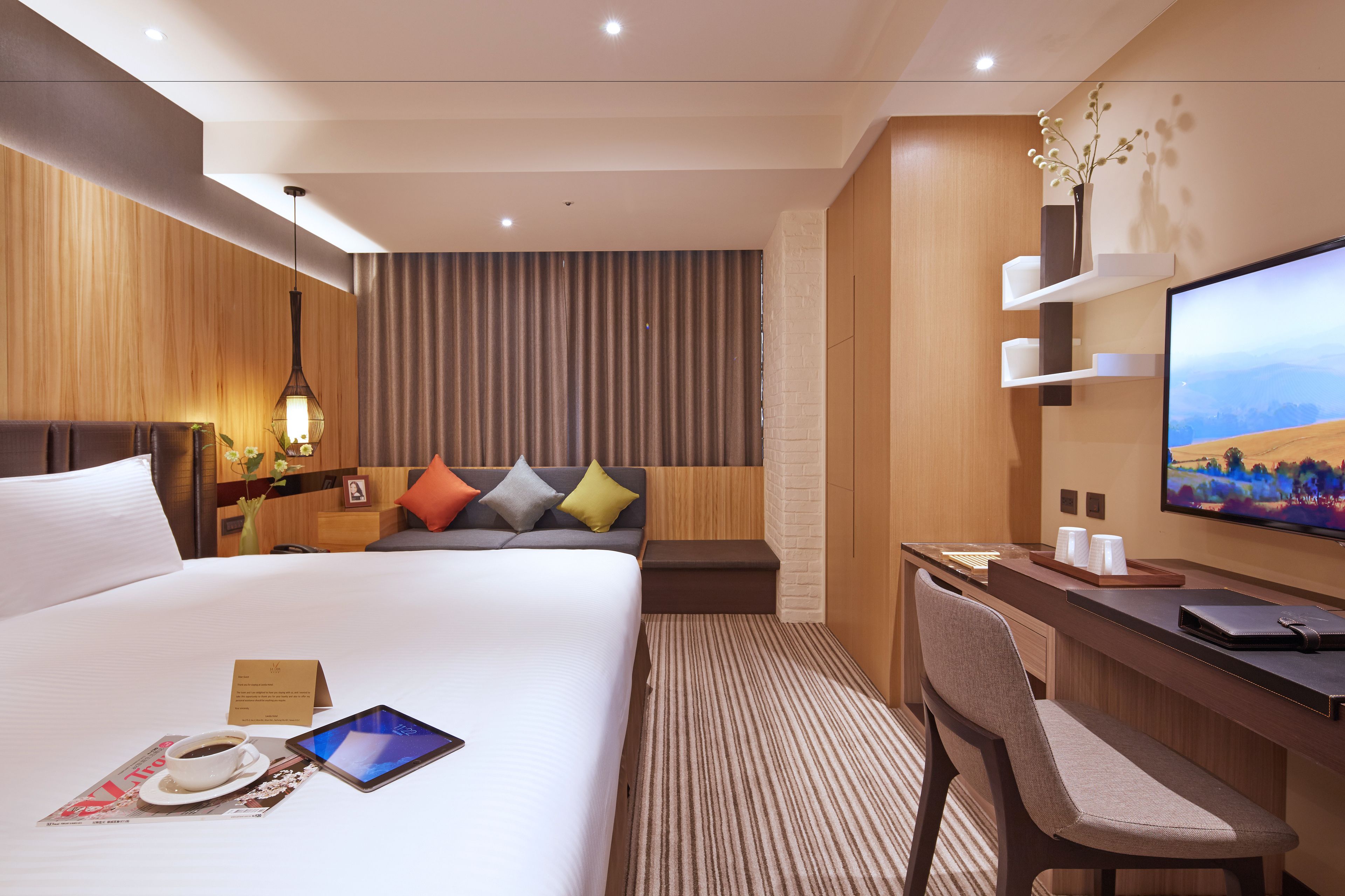 Een moderne hotelkamer met een groot bed, een bureau met stoel, een flatscreen televisie en uitzicht op de bergen.