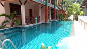 A swimming pool with tiled flooring, a covered seating area, and surrounding greenery. - Haad Yao Resort (Ko Pha-ngan)
