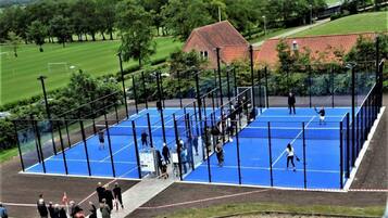 Guests can enjoy a game of tennis on our outdoor court, surrounded by lush greenery and a scenic view.