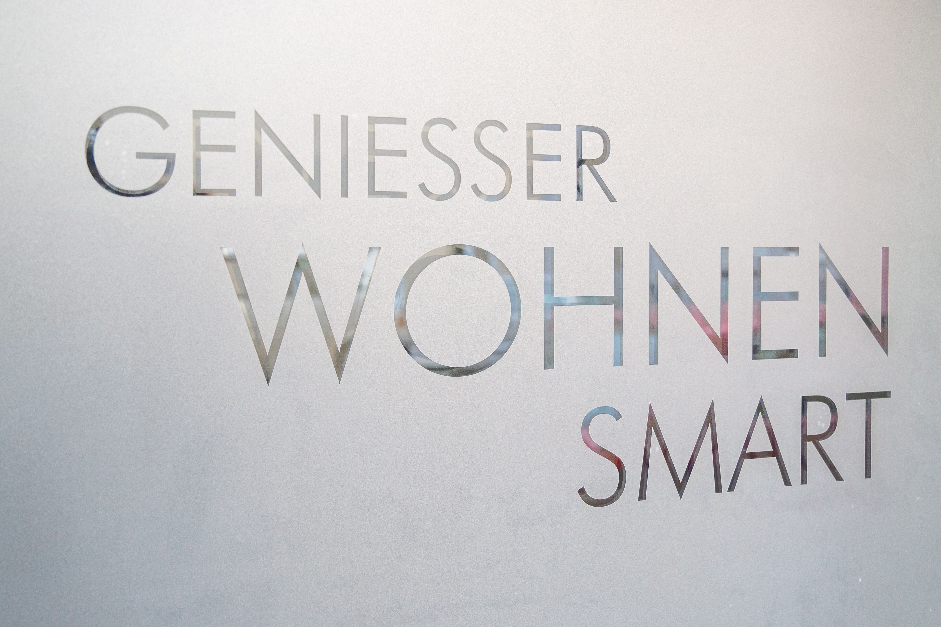 Ein Schild mit dem Text 'GENIESSER WOHNEN SMART'.
