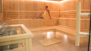 Un sauna avec des bancs en bois et une paroi en verre.