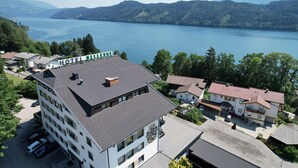 Un hôtel avec vue sur un lac et des montagnes. Il comporte plusieurs étages et dispose d’un parking.